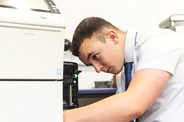 Technician providing quality support for business printers to ensure smooth operation