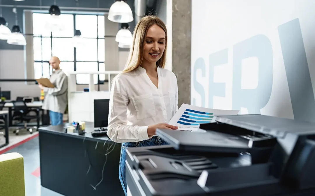 An office worker using a modern copier to duplicate important business documents, ensuring efficiency and streamlined workflow.